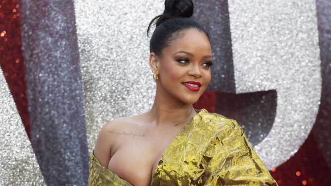 Rihanna luce un vestido dorado de Poiret cuyo tejido arrugado imita la textura del papel, drapeado y de largo asim&eacute;trico. Una elecci&oacute;n muy en la l&iacute;nea atrevida de la cantante y actriz, que completa su estilismo con sandalias y clutch dorados.