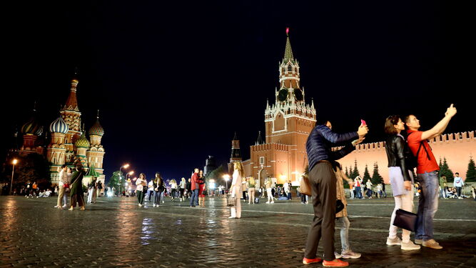 Unos jóvenes se hacen 'selfies' en la Plaza Roja de Moscú.