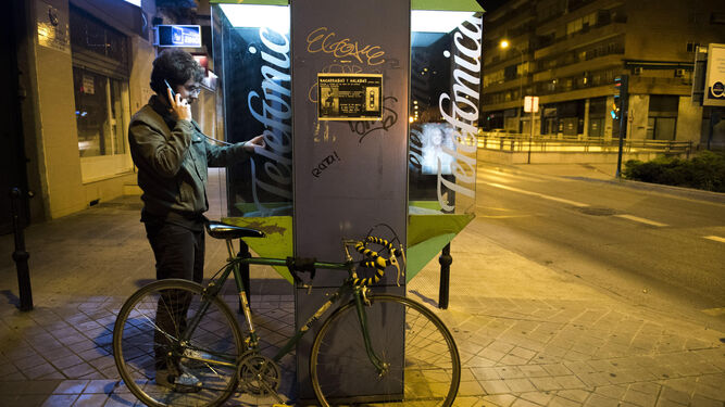 Una persona usa una cabina de teléfono para realizar una llamada en Avenida Andalucía.