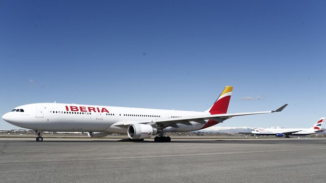 Un avión de Iberia, en primer plano, en el aeropuerto de Barajas.