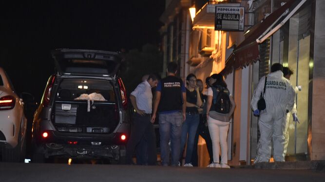 Familiares de la víctima y agentes de la Guardia Civil a las puertas de la joyería.