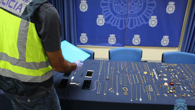 Un policía manipula los objetos recuperados.
