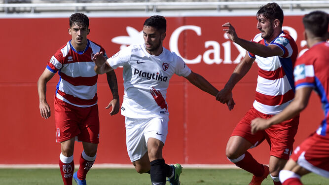 Yael y Eliseo, jugadores del Recreativo Granada, enciman a un jugador del Sevilla Atlético en el partido de ayer.