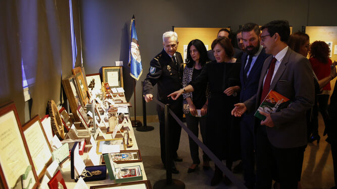 Las principales autoridades de la provincia y la capital reciben explicaciones de una de las mesas de la exposición que conmemora los 25 años de la Policía autonómica andaluza, y que se inauguró ayer en el Parque de las Ciencias.