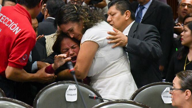 Varios legisladores consuelan a la diputada mexicana Carmen Medel Palma, tras saber que su hija había sido asesinada.