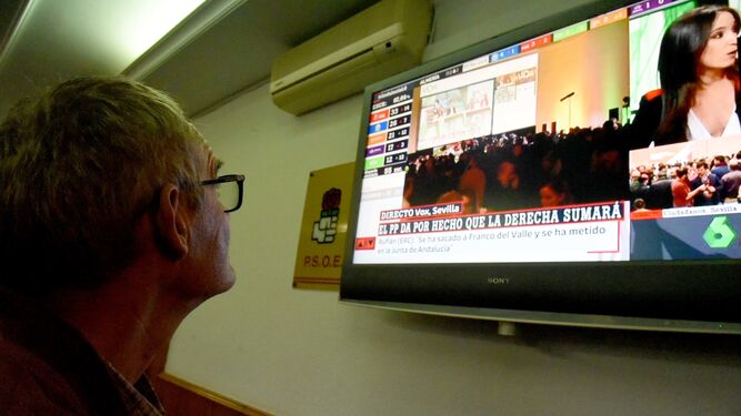 Un militante socialista sigue los resultados por televisión en la sede del partido en Algeciras.