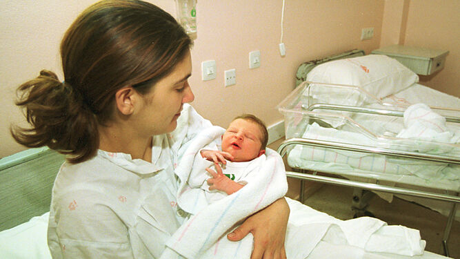 Una mujer sostiene en brazos a su hija recién nacida.