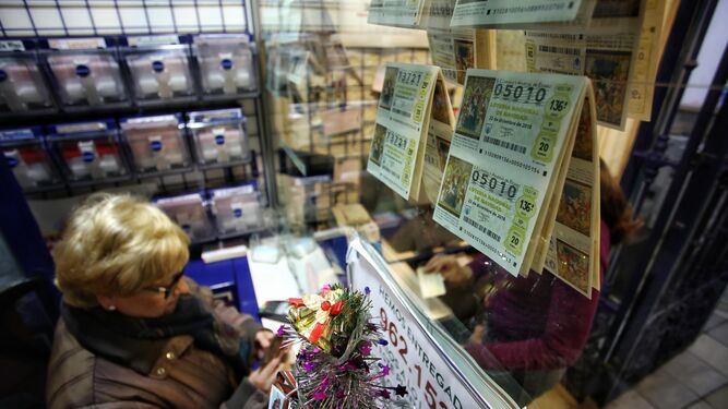Una mujer se interesa por unos décimos en la administración de loterías Arias en Cádiz.