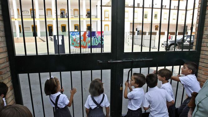 Escolares de la escuela concertada esperan en la puerta de un centro en Córdoba.