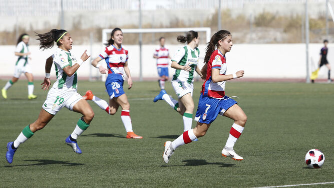 Una jugadora del Granada CF conduce el cuero perseguida por una rival.