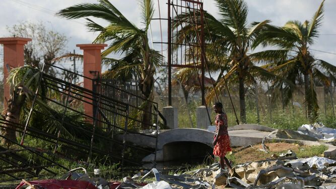 Una mujer busca entre los restos dejados por el ciclón materiales para reconstruir su casa.