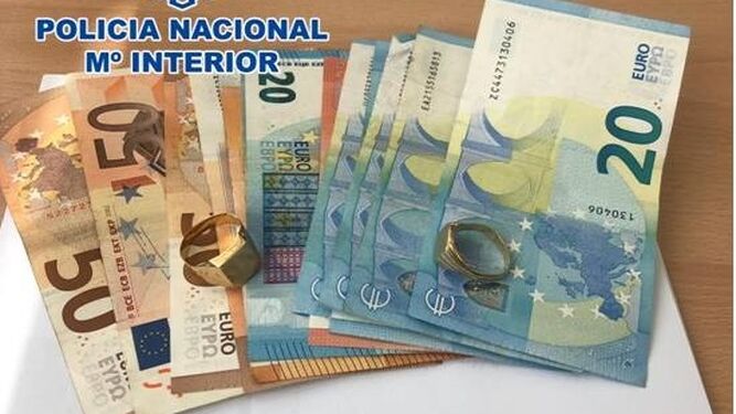 Imagen facilitada por la Policía Nacional del dinero y los dos anillos recuperados tras el robo.