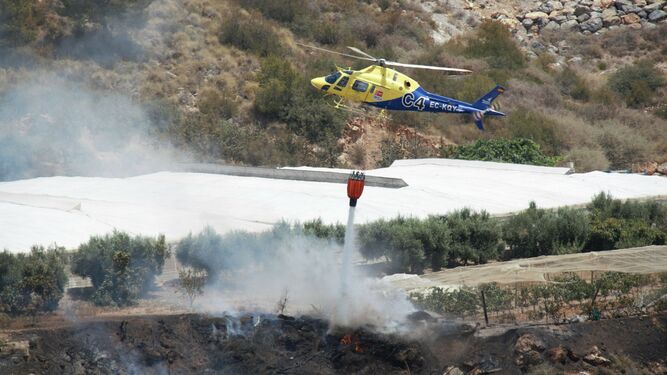 El helicóptero del Infoca, ayer, durante las labores de extinción en el incendio de Motril.