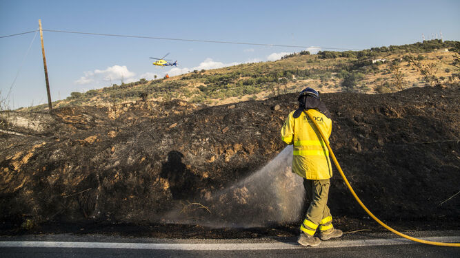 Un bombero del Infoca, durante las labores de extinción del incendio de El Fargue en la carretera de Víznar.