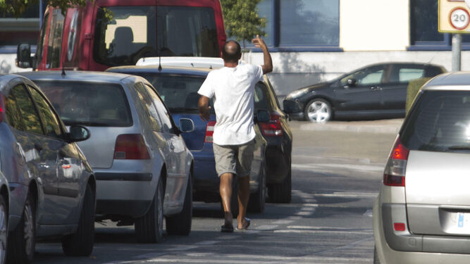 Un gorrilla señala un hueco para aparcar en la zona de la Plaza Toros de Granada.