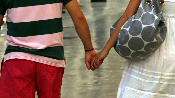 Una pareja pasea cogida de la mano por las calles de la ciudad.