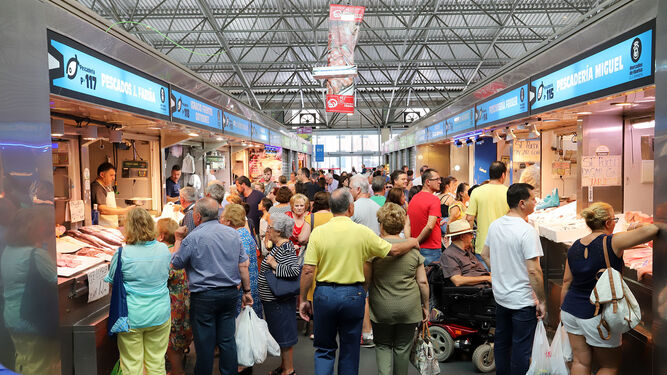 Personas haciendo compras en el mercado del Carmen de Huelva.