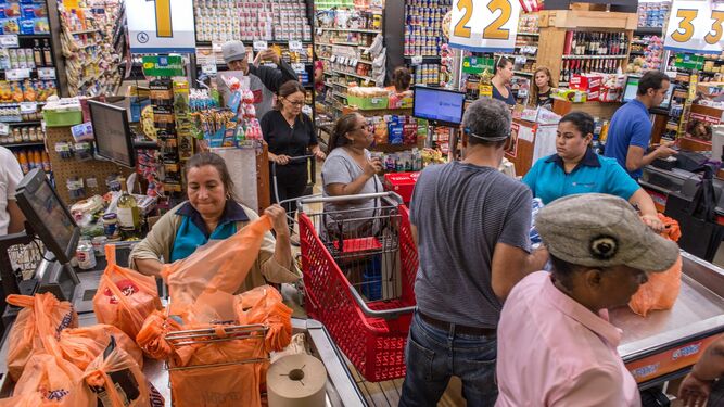 Personas se abastecen de víveres y agua en un supermercado de Florida.