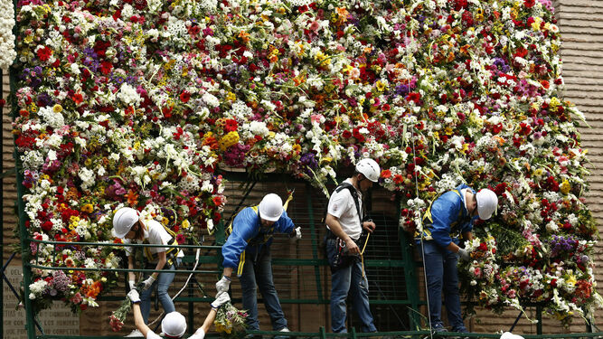 Imagen de los operarios colocando las flores en la basílica de la Virgen de las Angustias