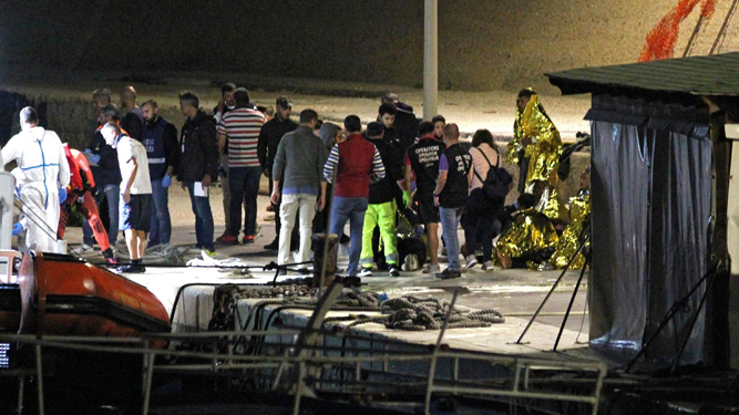 Los equipos de rescate atienden a los náufragos en el puerto de Lampedusa.