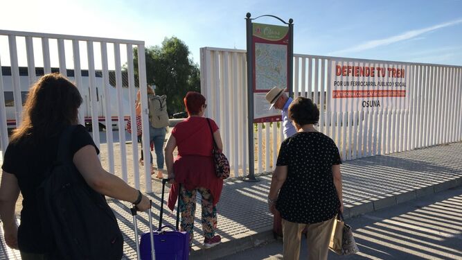 Viajeros procedentes de un tren de Málaga, transbordados al bus en Pedrera, vuelven a acceder a la estación de tren de Osuna.