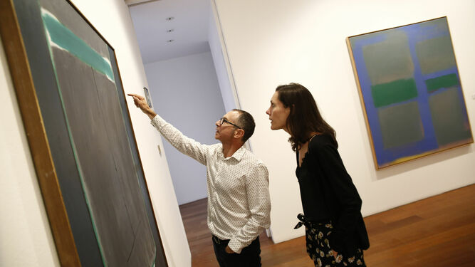 Ana Doldán y Francisco Baena, los comisarios de la exposición, observan una de las pinturas.