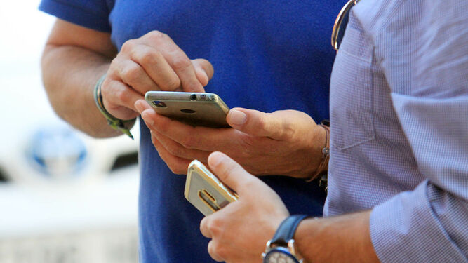 Dos hombres con sus móviles en las manos