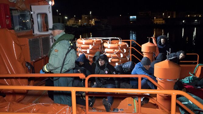 Un agente de la Guardia Civil junto a varios de los inmigrantes rescatados.