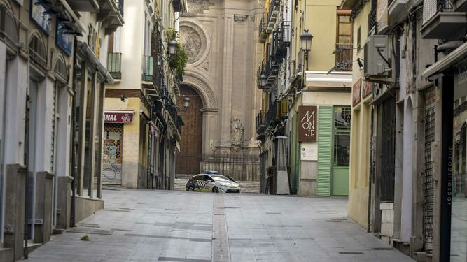 Un coche patrulla de la Policía Local de Granada en la Plaza de las Pasiegas, totalmente vacía
