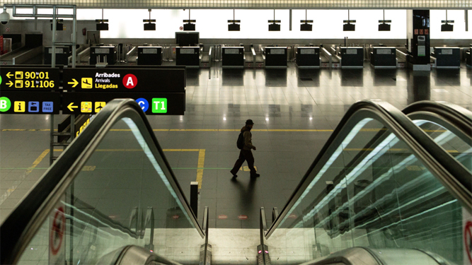 Una persona pasa por la desierta Terminal 2 en el Aeropuerto Barcelona-El Prat.