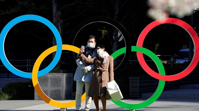 Una pareja se fotografía junto a los aros olímpicos en Tokio.