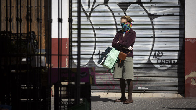 Una mujer haciendo cola para hacer la compra durante el confinamiento de la primera ola del virus.