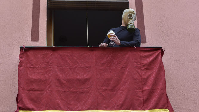 Un hombre con una mascara antigás, como las usadas en la Primera Guerra Mundial, en un balcón