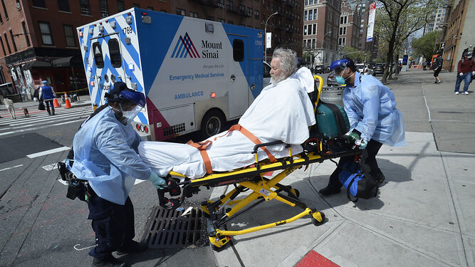 Dos sanitarios trasladan a un enfermo en una camilla