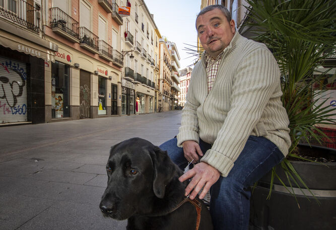 El granadino posa junto a su can, sus ojos en la calle.
