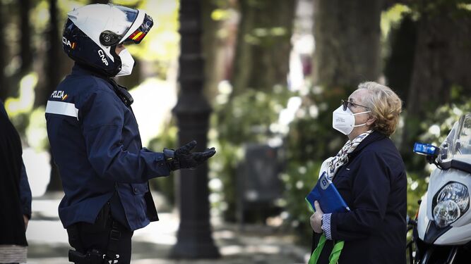 Un agente de la Policía Nacional de Granada conversa con una granadina.