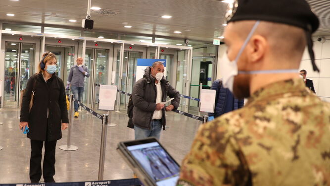 Un militar italiano hace controles de temperatura en un aeropuerto de Roma.