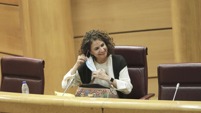 La ministra María Jesús Montero se quita una mascarilla para intervenir en el Senado.