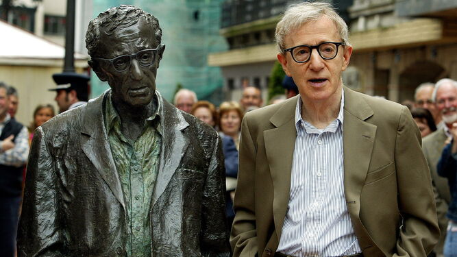El cineasta Woody Allen posa imitando a la estatua instalada en Oviedo en su honor.