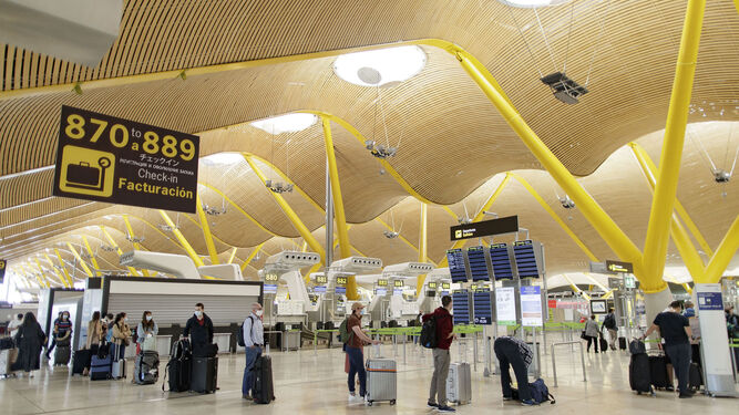 Pasajeros con sus maletas en las instalaciones de la Terminal T4 del Aeropuerto Adolfo Suárez Madrid-Barajas este viernes.