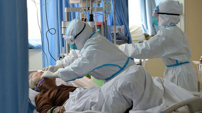 Dos médicos atendiendo a un enfermo de coronavirus en un hospital en Wuhan, China