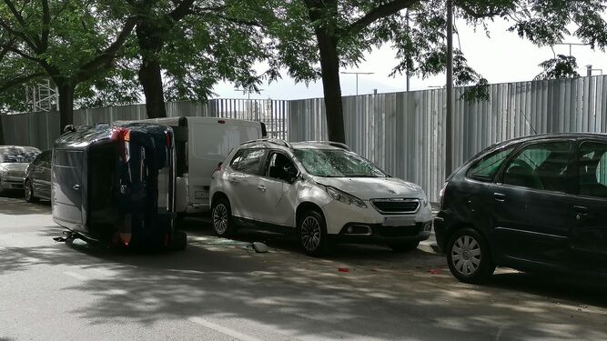 El coche volcado en la calle Halcón de Granada y no de los vehículos con los que ha impactado.