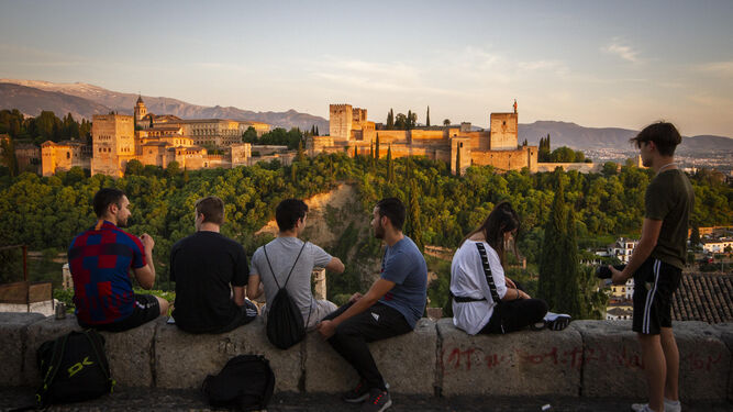 Varios turistas observan el atardecer desde el Mirador de San Nicolás de Granada.