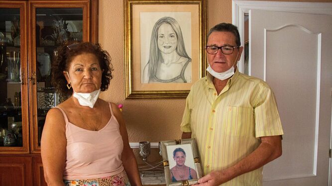 Los padres de María Teresa pasan en su casa con un retrato de su hija desaparecida.
