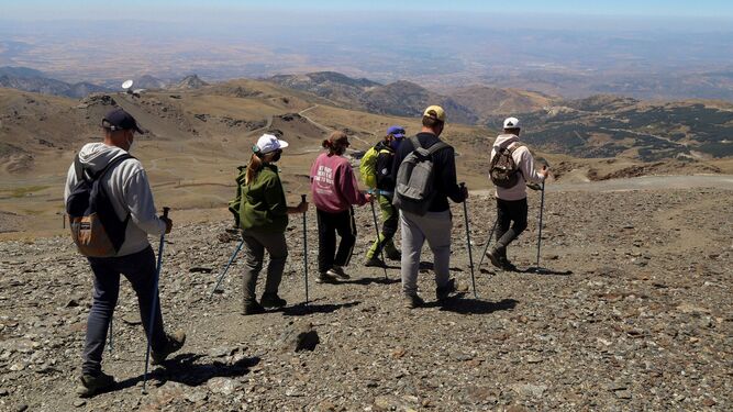 Varias personas practican trekking en Sierra Nevada.