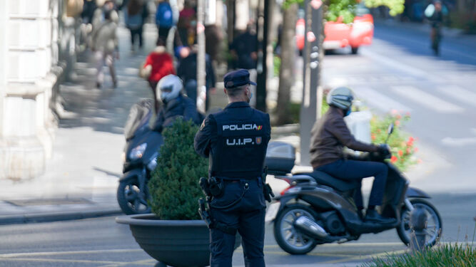 Un agente de la UIP de la Policía Nacional de Granada vela por el cumplimiento de las medidas.