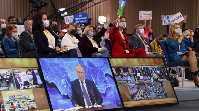 Periodistas miran la pantalla en la que aparece el presidente ruso, Vladimir Putiin, durante su conferencia de prensa anual en Moscú.