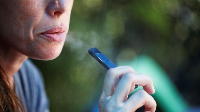 Una mujer fuma un cigarrillo electrónico.