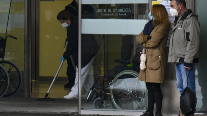 Dos familiares de un paciente aguardan en la puerta de Urgencias de un hospital