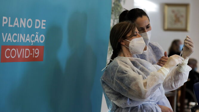 Dos sanitarias preparan una vacuna en la localidad lusa de Envendos.